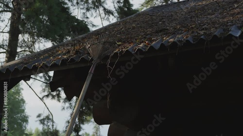 Close up shot of maintenance of a private home clearing the roof of a house from leaves and branches photo