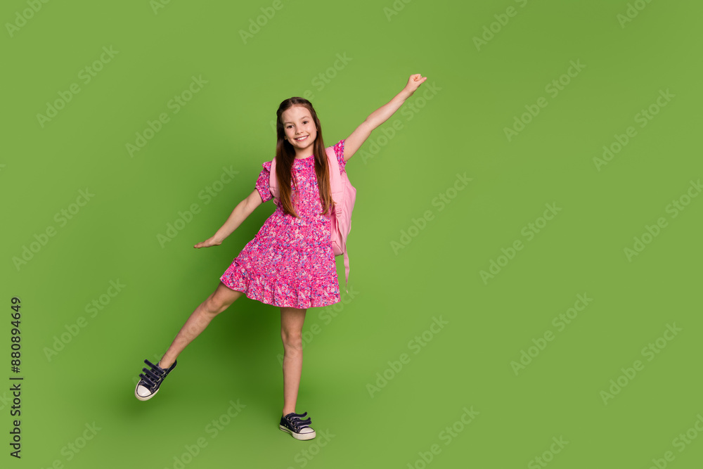 Full size photo of cute schoolgirl bag empty space wear pink dress isolated on green color background Full size photo of cute schoolgirl bag empty space wear pink dress isolated on green color background