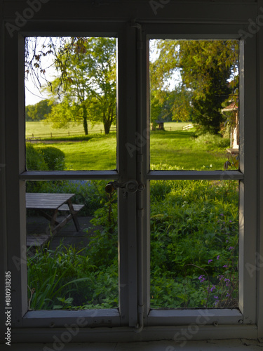 Blick aus dem Fenster in eine gruen, blühende Morgenlandschaft, View out of the window into a green, blooming morning landscape photo