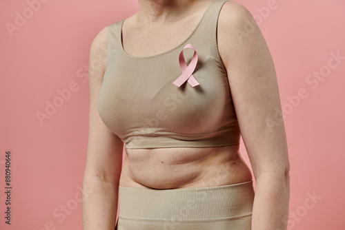 Wallpaper Mural A woman with short hair stands with a pink ribbon on her bra, demonstrating support for breast cancer awareness. Torontodigital.ca