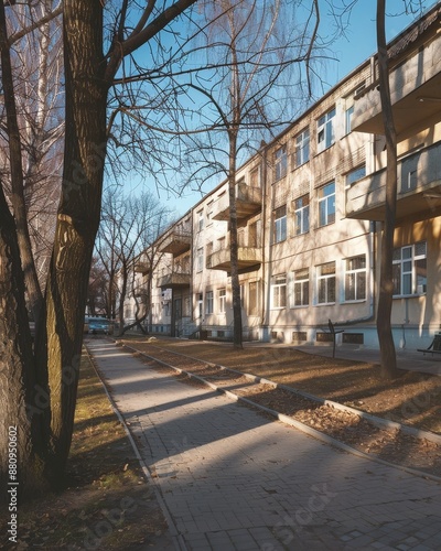 a sidewalk with a bench and a tree in front of a building