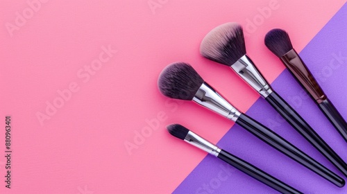 Makeup brushes on purple and pink background with top view and copy space