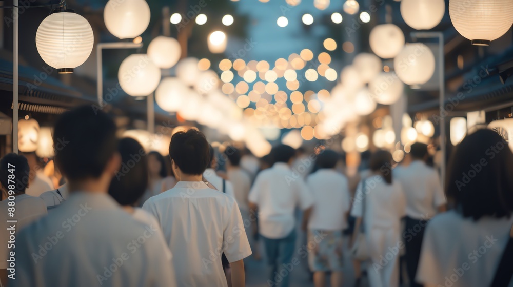 Crowd of people blurred walking through decorated street with glowing lanterns during festive evening event. Crowd of people blurred walking through decorated street with glowing lanterns during festive evening event.