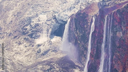 waterfall from glacier melting in upper himalayan mountains. Water streams coming down from rock cliffs during summer. Effect of global warming and climate change.
