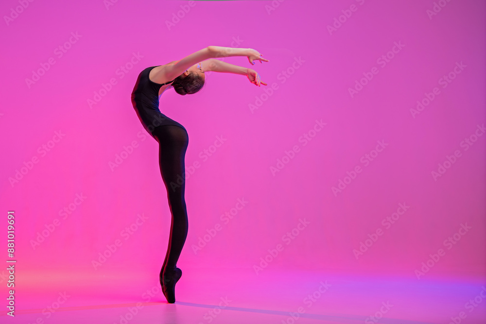 young ballerina in pointe shoes dances in black leotard and leotard on a red background young ballerina in pointe shoes dances in black leotard and leotard on a red background