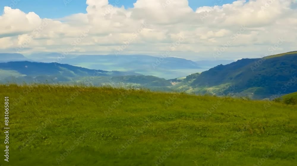 Panoramic natural landscape with green grass field, blue sky with clouds and mountains in background Panoramic natural landscape with green grass field, blue sky with clouds and mountains in background