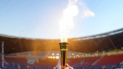 video Olympics golden torch with fire flame moving. Athlete holding Olympic fire. Sport in Stadium. photo