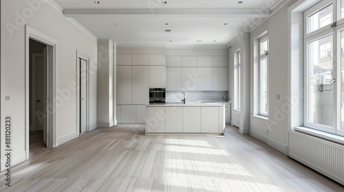 Wide angle view of a bright and modern empty kitchen with large windows and sleek cabinetry