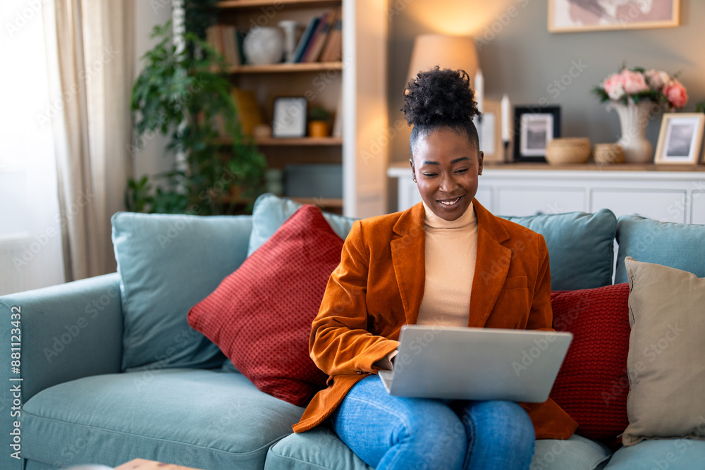 Young woman shopping online using laptop while sitting on sofa at home. Young woman shopping online using laptop while sitting on sofa at home.