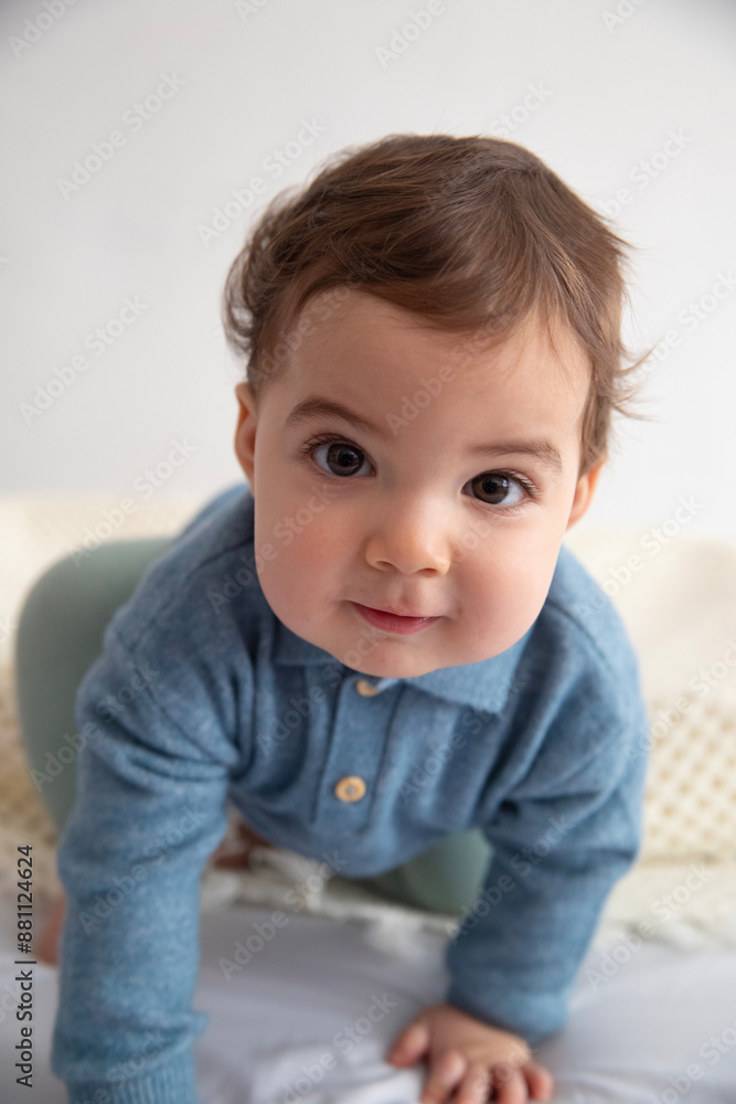 Curious Baby in Blue Sweater Crawling on Bed with Adorable Expression Curious Baby in Blue Sweater Crawling on Bed with Adorable Expression