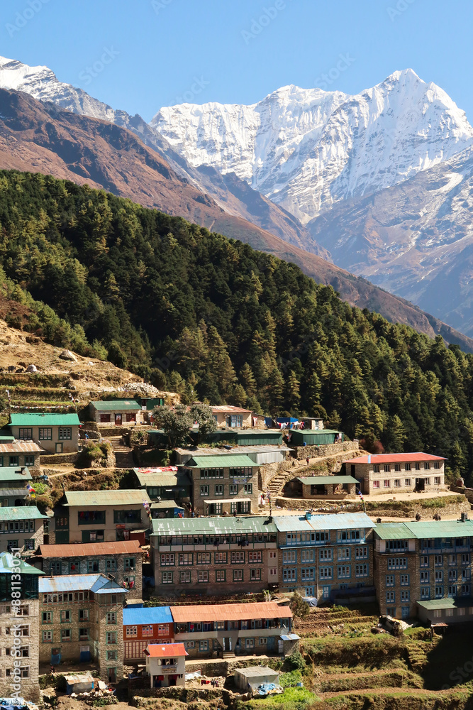 Obraz premium View onto a colorful neighborhood of Namche Bazaar, Bazar with Mount Kusum Kanguru, Kangguru rising in the background, Mount Everest Base Camp Trek, EBC, Nepal