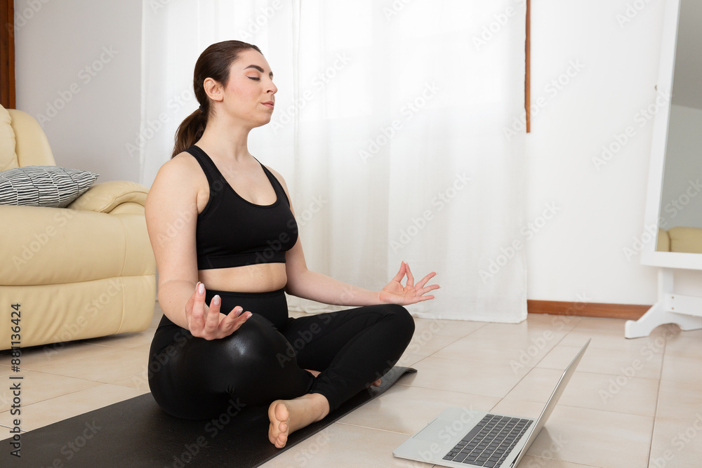 Young woman is practicing yoga at home watching online class on laptop Young woman is practicing yoga at home watching online class on laptop