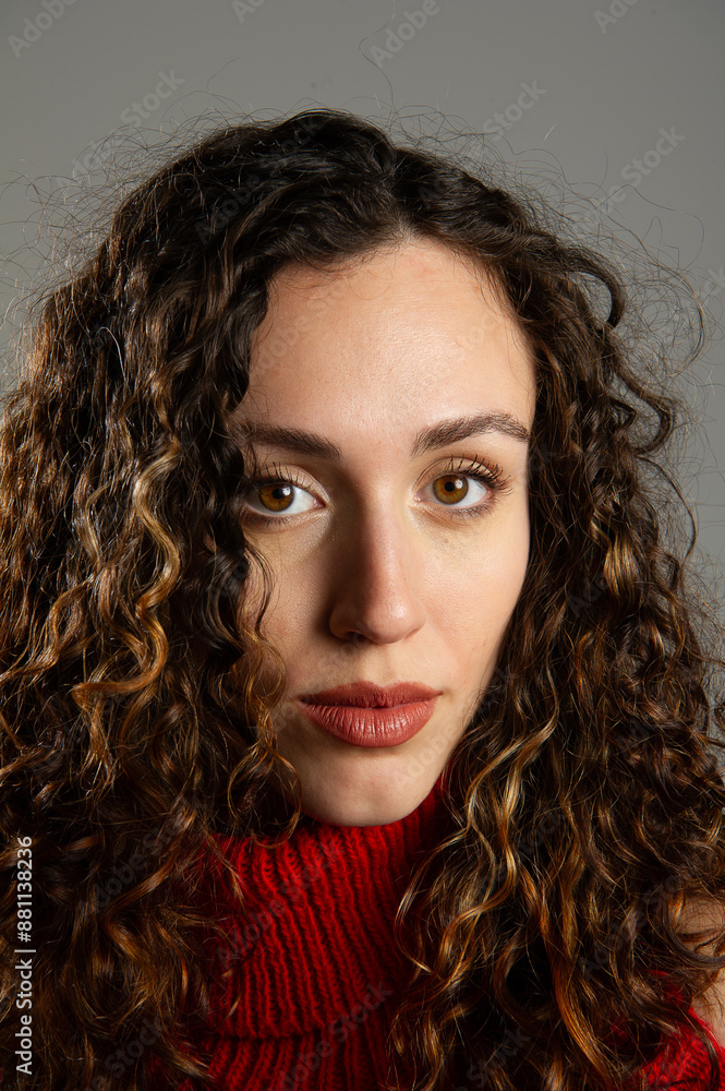 Young woman with long curly hair wearing red turtleneck Young woman with long curly hair wearing red turtleneck