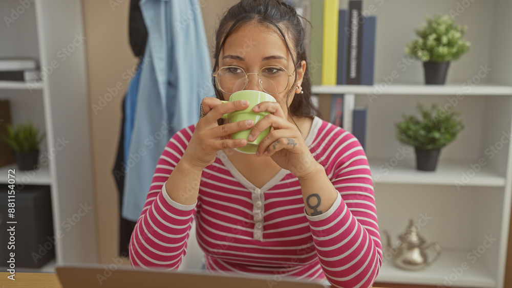 Young hispanic woman enjoying a break with coffee at her home office, showcasing a casual modern lifestyle. Young hispanic woman enjoying a break with coffee at her home office, showcasing a casual modern lifestyle.