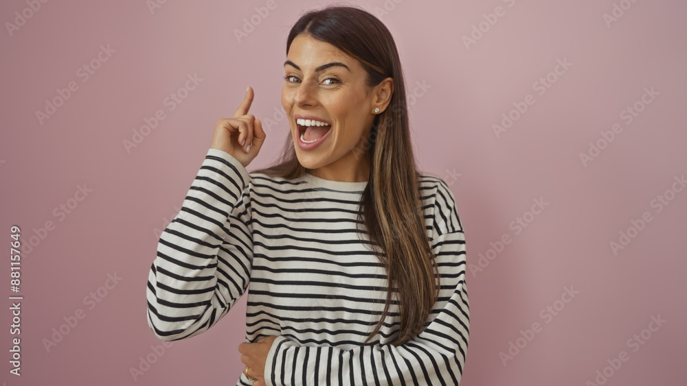 Hispanic woman in striped shirt gesturing idea against pink background Hispanic woman in striped shirt gesturing idea against pink background