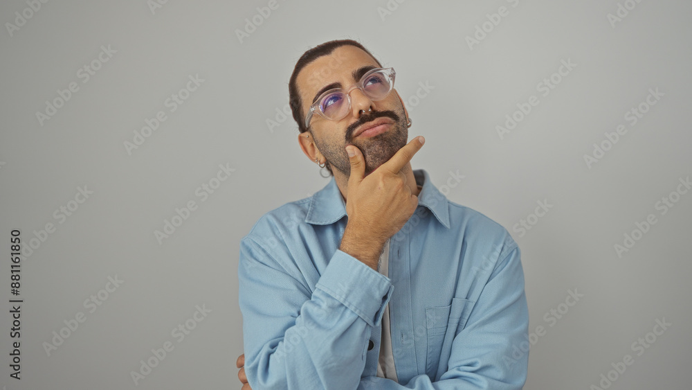 Young hispanic man with a moustache thinking thoughtfully while standing against an isolated white background Young hispanic man with a moustache thinking thoughtfully while standing against an isolated white background