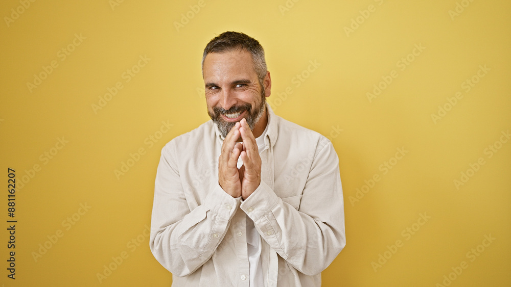 A cheerful mature hispanic man with grey beard smiling against a vibrant yellow background A cheerful mature hispanic man with grey beard smiling against a vibrant yellow background