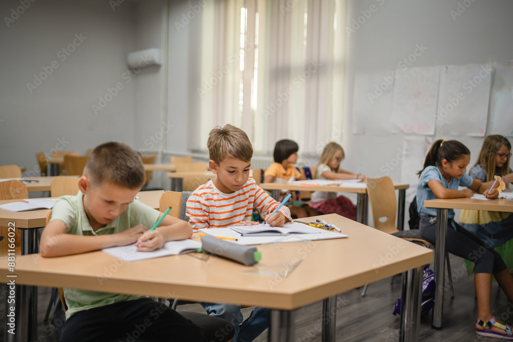 Young students do tasks and write on notebook on the class Young students do tasks and write on notebook on the class