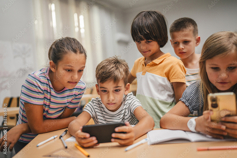 Young students use cellphone for video games on a break at school Young students use cellphone for video games on a break at school