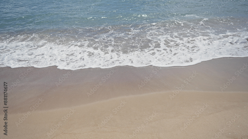 Sandy shore meets foamy ocean waves under clear blue skies Sandy shore meets foamy ocean waves under clear blue skies
