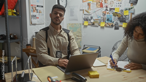 Man and woman detectives working in a cluttered police station office, analyzing evidence. photo