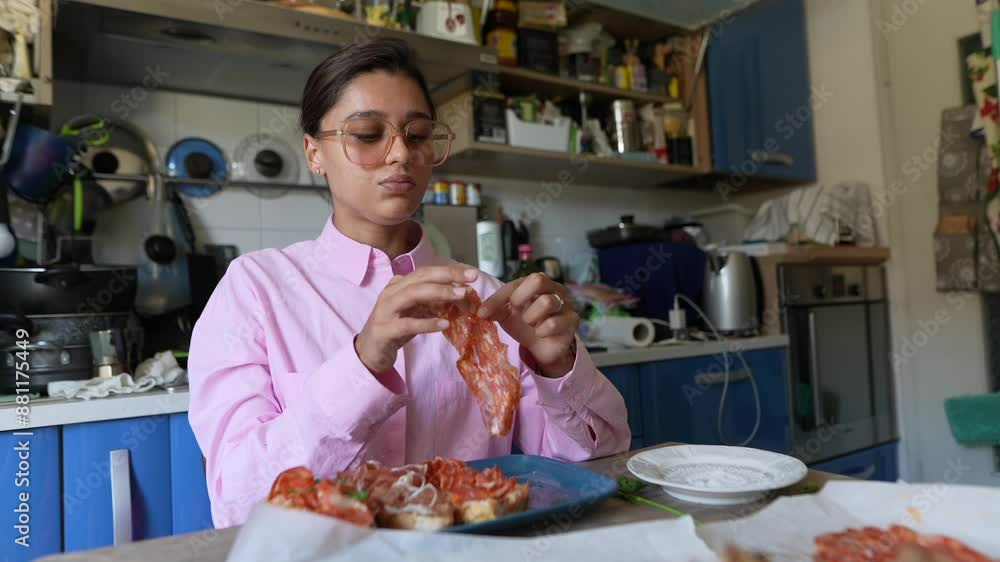 A woman is seen enjoying pizza in the warm and inviting ambiance of her home kitchen A woman is seen enjoying pizza in the warm and inviting ambiance of her home kitchen