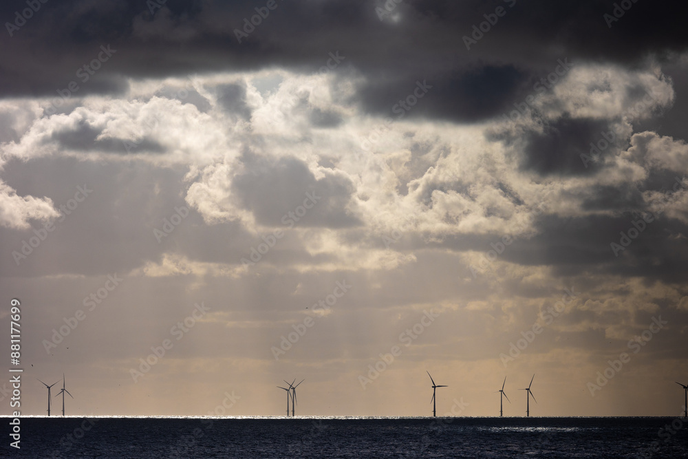 Dark clouds of a thunderstorm over silhouettes of wind turbines in the North sea Dark clouds of a thunderstorm over silhouettes of wind turbines in the North sea