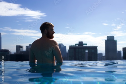 Photography silhouette of the back of a young man in an infinity pool enjoying his vacation