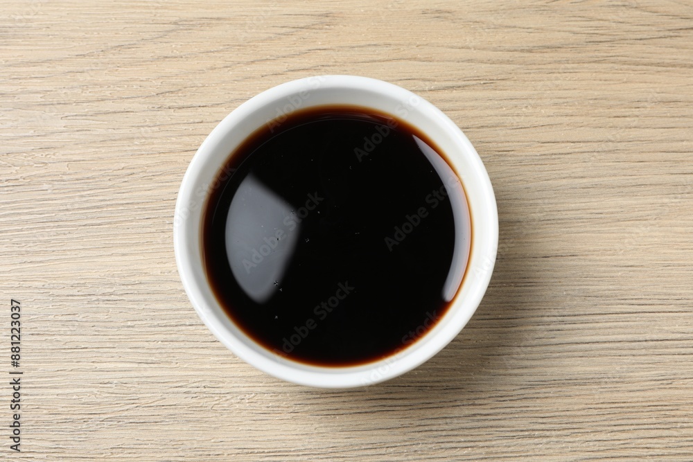 Balsamic vinegar in bowl on light wooden table, top view Balsamic vinegar in bowl on light wooden table, top view