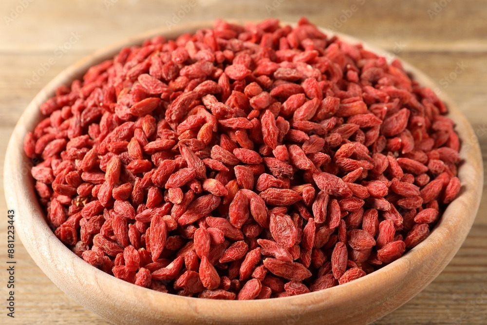 Dried goji berries in bowl on wooden table, closeup Dried goji berries in bowl on wooden table, closeup