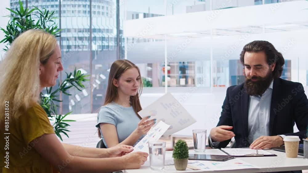 Financial adviser providing clients with informative leaflets on retirement planning, tax issues and wealth management. Agent in office assisting clients in setting up investment accounts, camera A