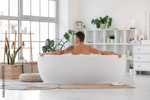 Handsome man taking bath wi...