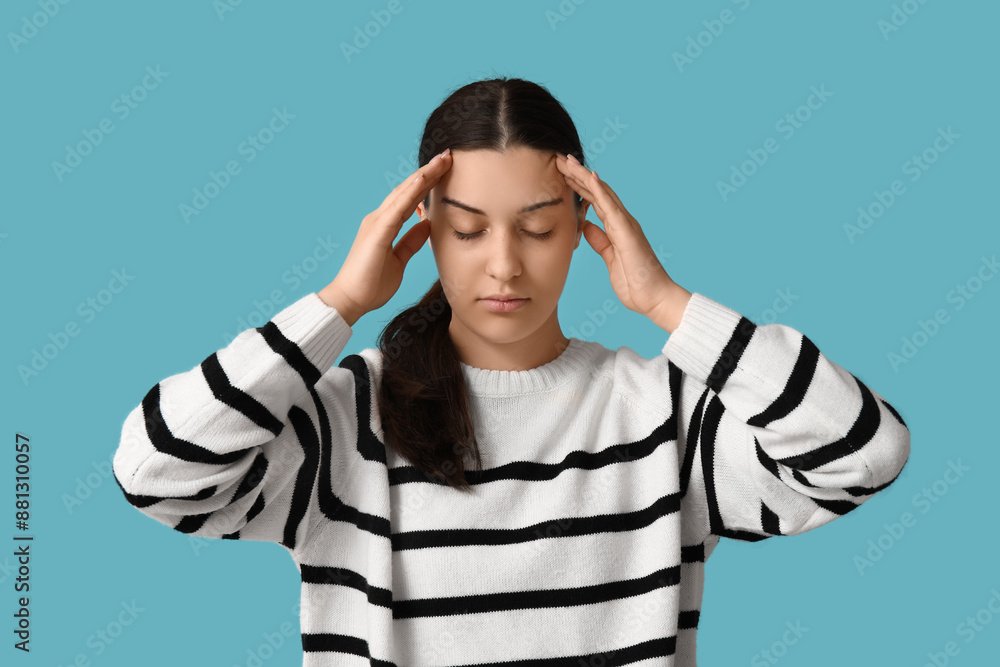 Beautiful young woman suffering from headache on blue background Beautiful young woman suffering from headache on blue background