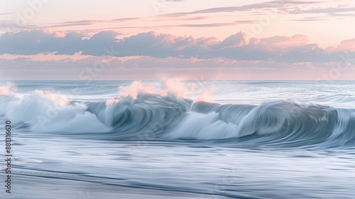 Large waves starting to form in a calm sea in the morning. Morning sky with soft pastel colors and stratus clouds.