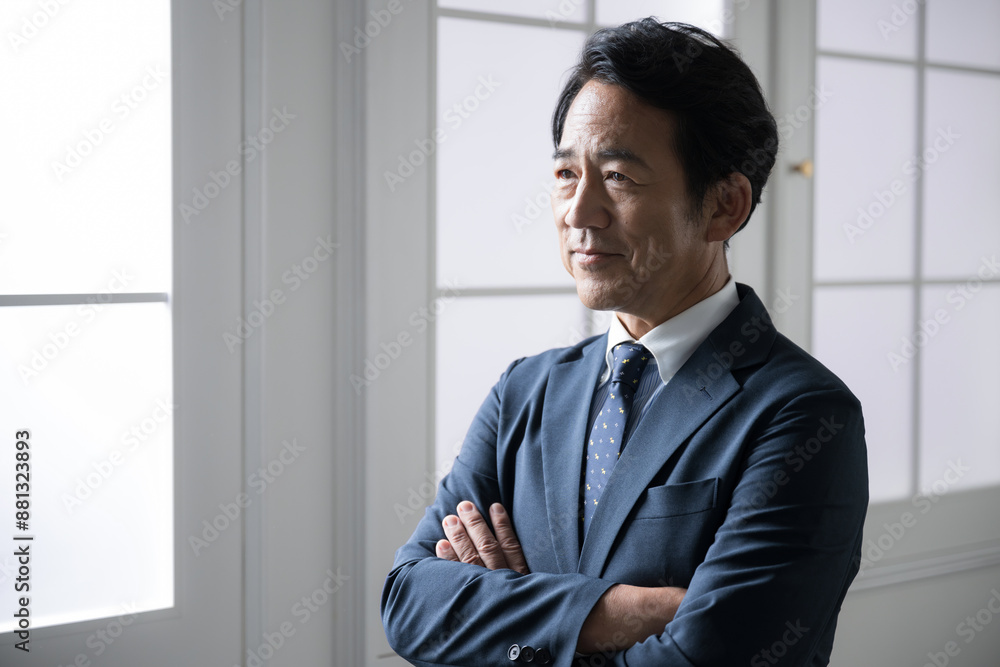 Handsome senior businessman with a serious look on his face, arms folded, profile of a manager or executive image. Handsome senior businessman with a serious look on his face, arms folded, profile of a manager or executive image.