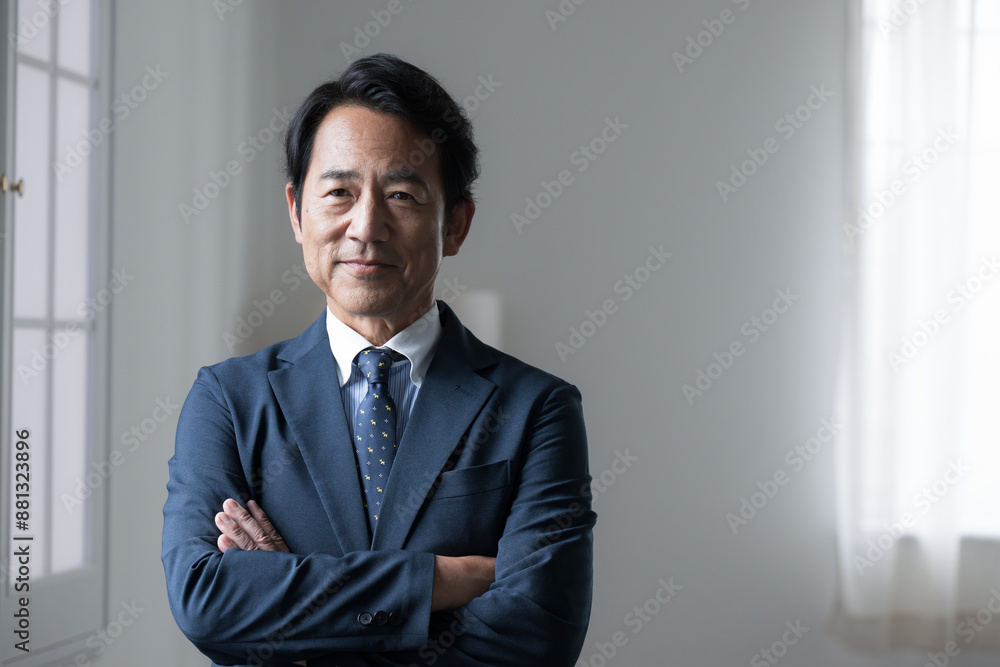 Handsome senior businessman with a serious look on his face, arms folded, managerial or executive image. Handsome senior businessman with a serious look on his face, arms folded, managerial or executive image.