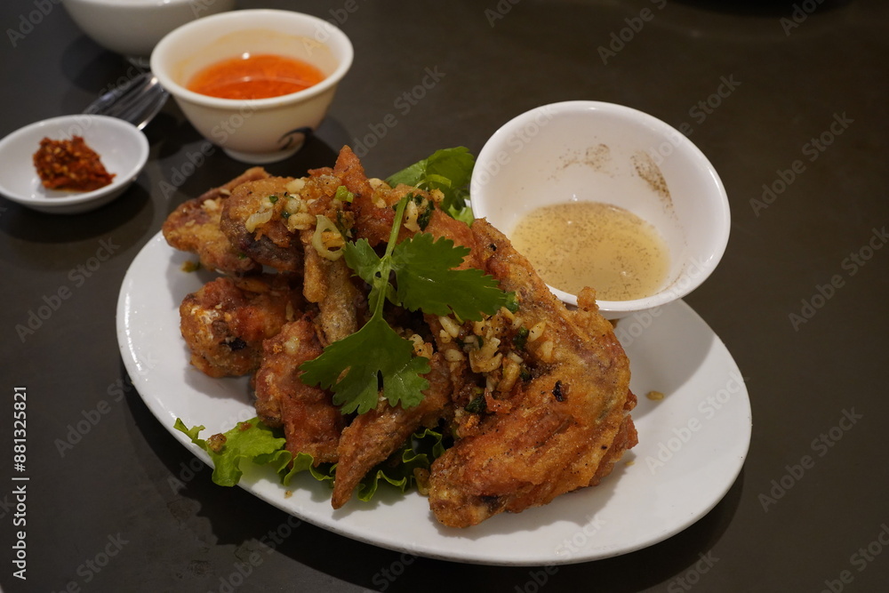 deep fried chicken with garlic, along with a bowl of lemon and pepper sauce 