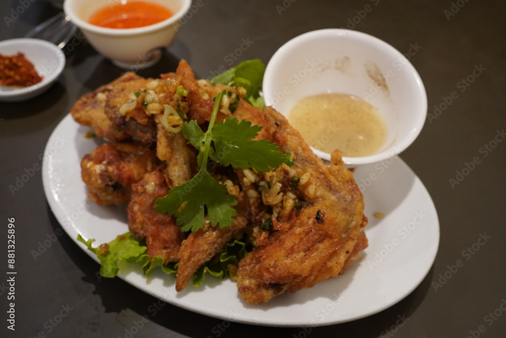 deep fried chicken with garlic, along with a bowl of lemon and pepper sauce deep fried chicken with garlic, along with a bowl of lemon and pepper sauce