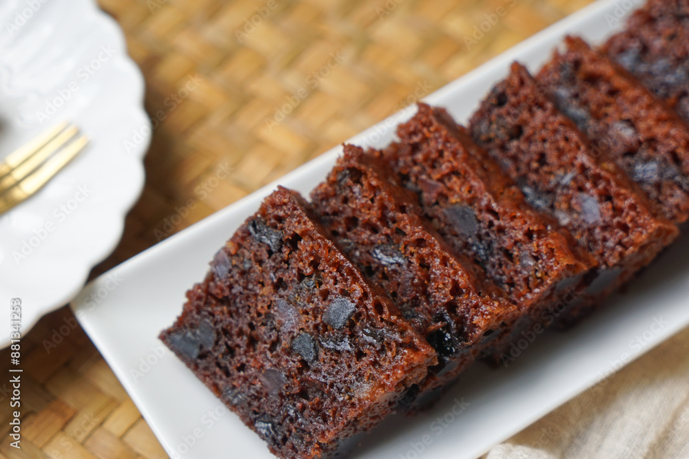 Kek Buah Kukus, a traditional Malaysian steamed fruit cake filled with dried fruits, nuts, and spices, enjoyed during celebrations. Kek Buah Kukus, a traditional Malaysian steamed fruit cake filled with dried fruits, nuts, and spices, enjoyed during celebrations.
