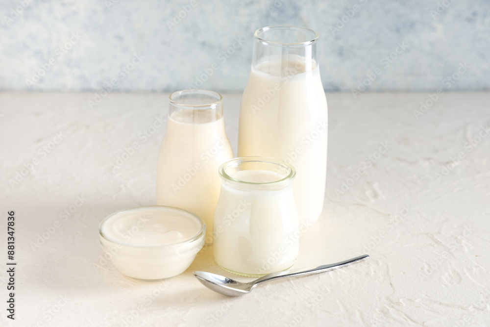 Bottles and glass bowl of tasty yogurt on white background Bottles and glass bowl of tasty yogurt on white background