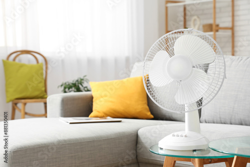 Modern electric fan on coffee table at home photo