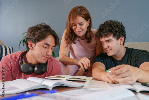 Hijos con su mamá en una sesión de estudio en casa, recibiendo explicación y estudiando.