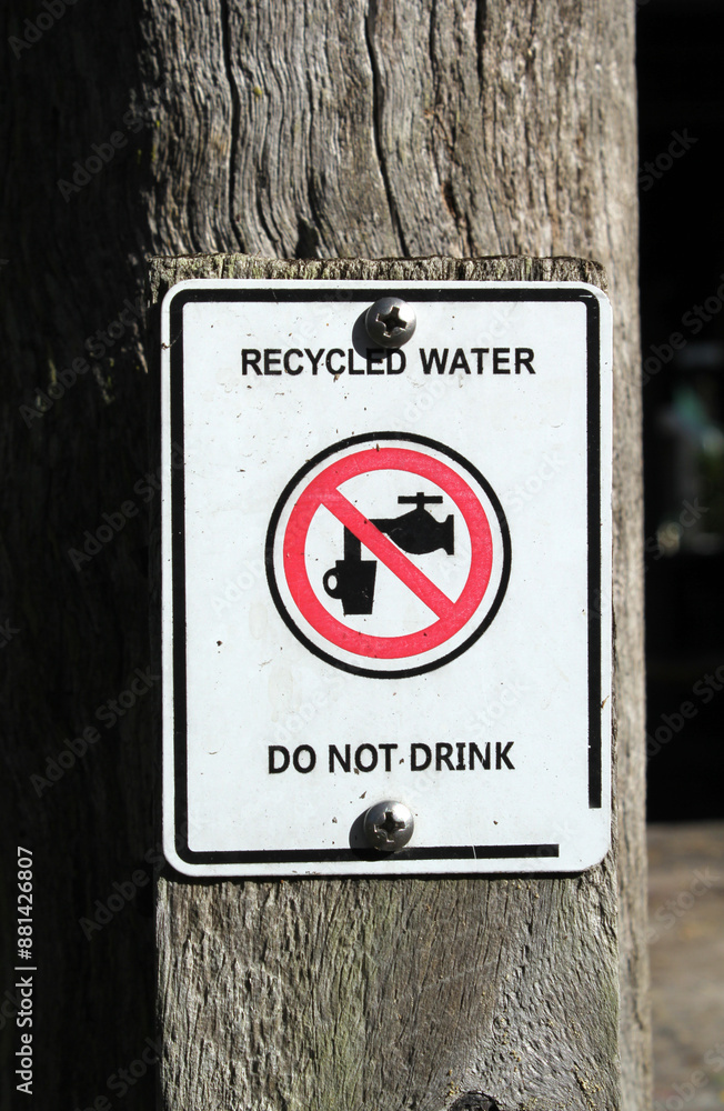Recycled Water - Do Not Drink sign mounted on a wooden post Recycled Water - Do Not Drink sign mounted on a wooden post