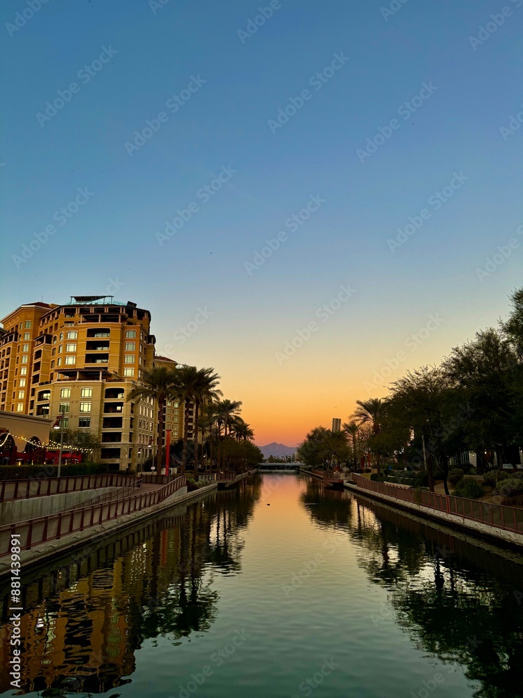 Fototapeta premium sunset on a perfectly clear night reflecting over the river lined with palm trees