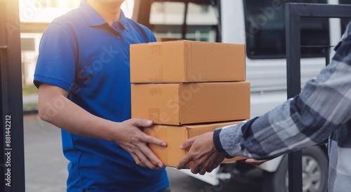 Foto Asian delivery express courier young man use giving boxes to woman customer he w