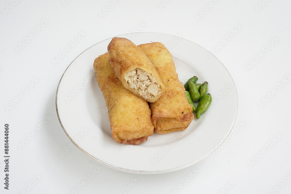 ‘Sosis solo’ or fried egg crepe with minced beef or chicken filling. This common Indonesia snack is served with chili pepper on white plate isolated in white background ‘Sosis solo’ or fried egg crepe with minced beef or chicken filling. This common Indonesia snack is served with chili pepper on white plate isolated in white background