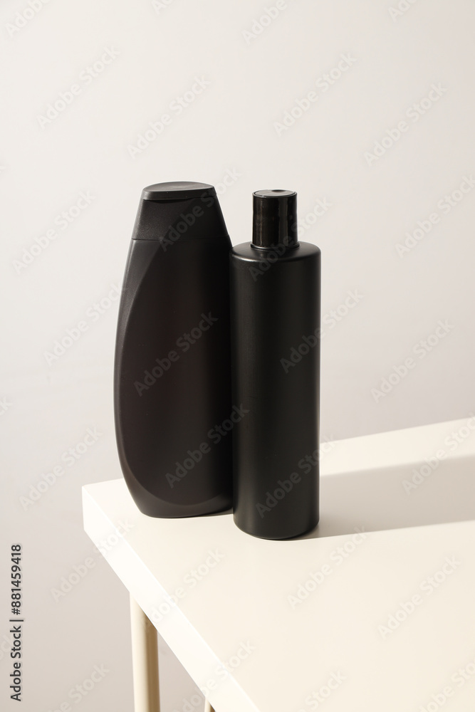 Two black bottles with men's cosmetics on table on white background Two black bottles with men's cosmetics on table on white background
