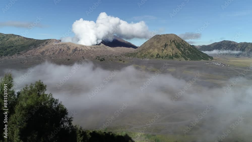 Aerial View of Mount Bromo in the Middle of a Sea of Sand Bromo Tengger Semeru National Park and clouds. Aerial View of Mount Bromo in the Middle of a Sea of Sand Bromo Tengger Semeru National Park and clouds.