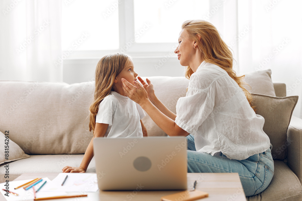 Mother and daughter enjoying quality time together while learning on a laptop in a cozy living room setting Mother and daughter enjoying quality time together while learning on a laptop in a cozy living room setting