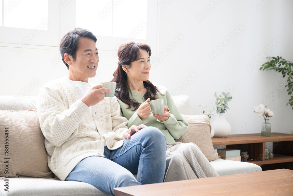 Full body of a couple in their 50s relaxing in the living room Profile of a couple having a conversation